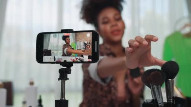 Arka görüş telefon ekranı kadın nüfuzu kaydedicisi canlı yayın yapan video bloğu gözden geçirme makyaj kritik sosyal medya veya blog. Çevrimiçi pazarlama yayını için kozmetik ürünleri olan genç bir kız.