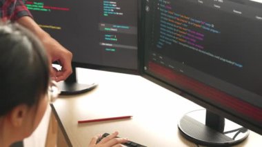 Yavaş çekimde geri uç veya yazılım geliştirici yöneticisi ekibini monitörde hata ayıklama ve karmaşık kod algoritmalarını çözmede yeni uygulama programı geliştirmede denetliyor. Filizlenen
