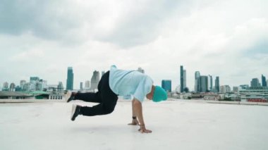 Beyaz dansçı çocuk çatıda sokak dansı pratiği yapıyor. Sokak dansını icra eden ya da pratik yapan yetenekli break dansçı ve hip-hop dansçısı. Açık hava sporu 2024. Hareket eden kamera. hiphop.