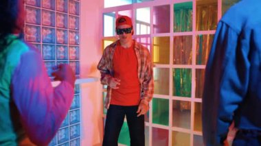 Kafkas dansçısı dans ederken çeşitli arkadaşları gece kulübünde neon ışıkta ayak seslerine bakıyor. Çoklu etnik kökenli hipsterin serbest stil müziğe geçişi ve mutlu bir adamın kameraya bakışıyla. Mutluluk.