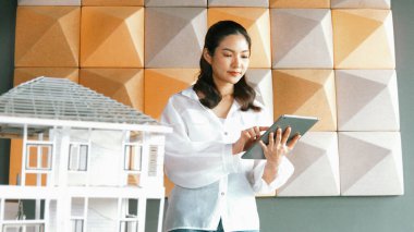 Tablet kontrol evi modelini kullanan güzel bir proje yöneticisi. Mimar mühendisinin portresi tabletteki veri analizini kullanarak bina inşaatını denetliyor. İş inşaat konsepti. Yönlendirici.