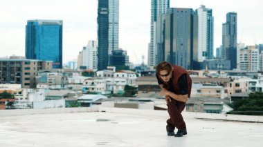 Profesyonel Asyalı break dansçı B çocuk dansı yaparken çatıda çok kültürlü arkadaşlar var. Genç modern dans grubu hip hop hareketi yapıyor. Tarz, moda, aksiyon. Açık hava sporu 2024. ÇalışmaComment.