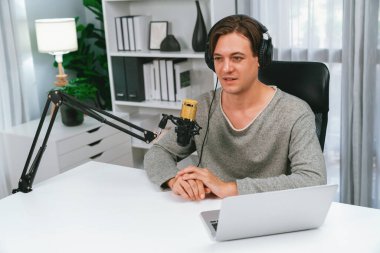 Sunucu kanalı, gülümseyen akıllı yayıncı kaydı, senaryosu ve akıllı telefonuyla sosyal medyada sohbet programı, kulaklık takarak modern ev stüdyosundaki video flamalarını kaydediyor. Bireysel.