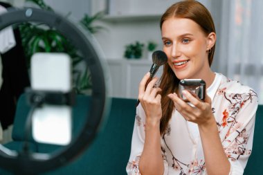 Kadın Etkilenen Vlog video görüntülerini sosyal medya ya da blog 'da en üst düzeyde yayınlıyor. Kozmetik stüdyosu ışıklandırmalı mutlu genç kız çevrimiçi pazarlama oturumu yayını için..