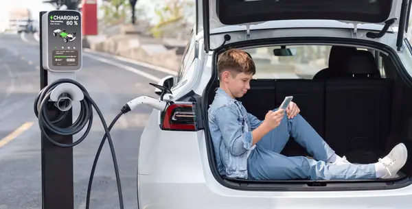 Маленький Мальчик Сидит Багажнике Автомобиля Используя Смартфон Подзаряжая Экологически Чистый — стоковое фото