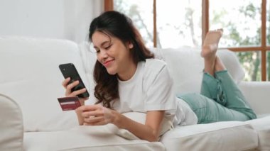 Kadın alışverişi ya da internet pazarında online ödeme modern yaşam tarzı için satılık eşyalar arıyor ve canlı siber güvenlik yazılımı tarafından korunan cüzdandan çevrimiçi ödeme için kredi kartı kullanıyor