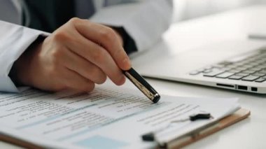 Hastanedeki doktor masasında oturup hasta test sonuçlarını teşhis eden, hastalıklar ve hastalıklar için tedavi planı geliştiren evrak işleriyle uğraşıyor. Sağlık personeli ve sağlık hizmetleri. Ağır çekim. Katı.