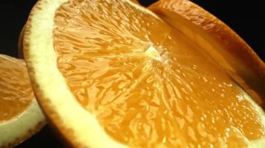 Portakal diliminin bir makrografi görüntüsü, parlak, izole edilmiş bir arkaplan üzerine yerleştirilmiş, narenciye cazibesinin görsel bir başyapıtı olarak gözler önüne seriliyor. Siyah arkaplanlı bir dilim portakal. Geliştirilebilir.