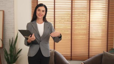 Mutlu ve gülümseyen kadın psikolog psikiyatri ofisinde ya da terapi odasında pano tutuyor. Arkadaş canlısı ve profesyonel ruh sağlığı danışmanı ya da terapisti. Blithe