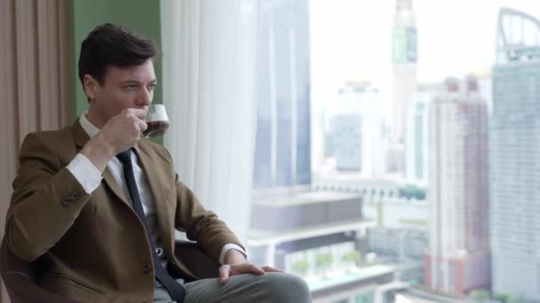 Geschäftsmann Sitzt Auf Möbeln Und Trinkt Kaffee Während Laptop Verzierten — Stockvideo