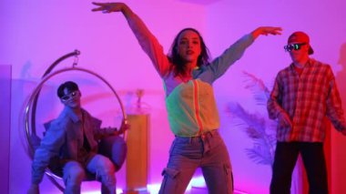 İspanyol hipster renkli kıyafetler giyer ve serbest stil müziğe el sallar. Profesyonel break dansçı neon ışıklarıyla ve modern stüdyo arkadaşlarıyla coşkuyla dans ediyor. Mutluluk.