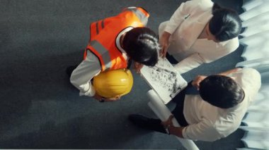 Yetenekli mimar mühendis ekibinin planlara birlikte baktığı en iyi manzara. Birlikte çalışırken tablet tutan akıllı tasarımcıların hava görüntüsü ve yapı hakkında beyin fırtınası. Hizalama.