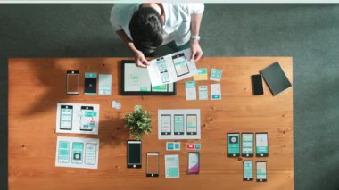 İş adamının toplantı odasında Ux Ui tasarımına bakması ve onu seçmesi. Yetenekli geliştirici yaratıcı iş yerinde cep telefonu arayüzü ya da yazılım uygulaması tasarlıyor ve planlıyor. Cemaat.