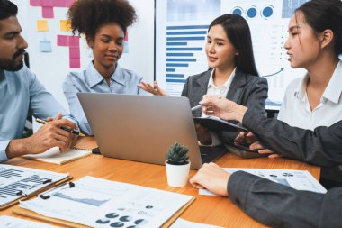 Çok ırklı analist ekibi toplantı masasındaki mali raporu analiz etmek için BI gösterge tablosunu kullanıyor. Çeşitli iş adamlarından oluşan bir grup, FIntech 'in veri analizini başarılı iş pazarlaması için kullanır. Uyum