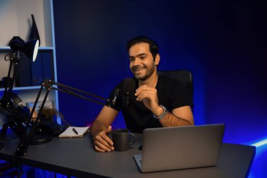 Yayıncı, fanclub dinleyicisiyle mikrofon kullanarak konuşuyor. Mor neon ışıklı modern stüdyoda yaratıcı olumlu düşünce konseptiyle canlı yayında finansal sorunları tartışıyor. Tahmin et..