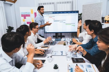 Proje yöneticisi monitörde proje yönetimi yazılım görüntülemesi, proje görevinin ilerlemesini izlemek ve toplantı masasında program planı yapmak suretiyle ekiple iletişim kurar ve işbirliği yapar. Tedbirli