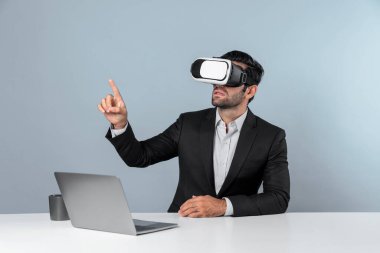 Bilgisayarla masada otururken ve VR gözlüğü takarken veri analizine bakan yetenekli bir iş adamı. Proje yöneticisi sanal gerçeklik sistemini kullanarak ya da metaevrende bağlantı kurarak çalışıyor. Sapma.