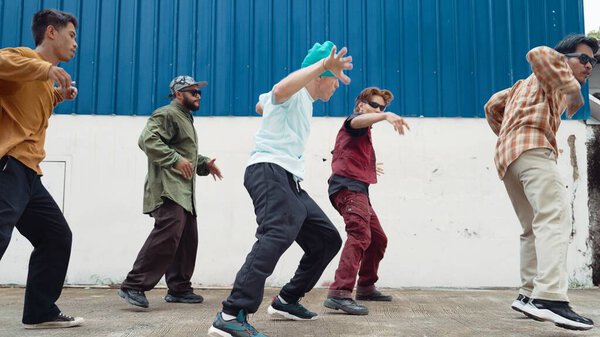 Group of hip hop choreographer dancing street dance together at wall. Young break dancer practicing break dance, moving to modern rhythm, express feeling of lively. Outdoor 2024. Endeavor.