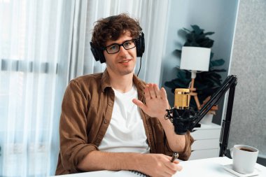 Kulaklık ve mikrofon kullanan etkili sunucu kanalı. Dinleyicilerle sosyal medyada canlı yayında konuşuyorlar. Stüdyo ofisindeki müşteri hedeflemesi için yaşam koçluğu ve eğitim pazarlama planları yapıyorlar. Toplayıcı.