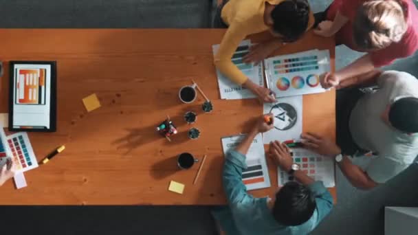 カラーパレットから色を選択するために協力するビジネスチームの時間の経過 プロジェクトマネージャーは ロゴグラフィックを見ているビジネスマンしながら マーケティングチームにタブレットを使用してアイデアを提示します シンポジウム — ストック動画
