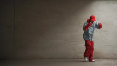 Profesyonel Asyalı hipster gri arka planlı break dansçı performansı sergiledi. Çekici bir sokak dansçısı şık kıyafetler giyerken hareketli hareketler yapar. Açık hava sporu 2024. Uzayı kopyala Yumuşak bir şekilde..