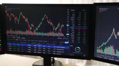 Hisse senedi borsası pazarlamasını analiz eden yavaş çekim şirketindeki yatırımcılar, kayıp için mum bar fiyatını analiz eden monitörlere bakıyor ve kazanç ve kâr elde ediyor. Filizlenen