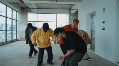 Çok kültürlü dansçılar sokak dansı yapıyor ve hip-hop müziğine geçiyorlar. Profesyonel hipster grubu gökyüzü kavgacı görünümlü bir binada serbest stil müzik eşliğinde dans ediyor. Açık hava sporu 2024 hiphop..