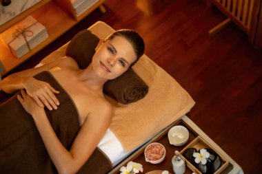 Beyaz kadın müşteri stres önleyici spa masajının keyfini çıkarıyor ve lüks otel ya da otelde sıcak mum ışığında güzellik teniyle eğleniyor. Sessiz.