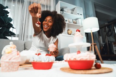 Genç ve güzel Afrikalı blogcu, pastel renkte özel mutfaklar gösteren bir kek sunuyor. Favori tatlı fırın yemeğiyle sosyal medyanın yaratılması. Tatlandırıcı.