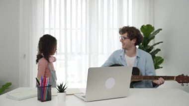 Babam gitar çalarken, kulaklık takıp, akustik müzik eşliğinde dans eden mutlu okul kızı. Gülümseyen çocuk müzik dinlerken baba şarkısının keyfini çıkarıyor. Aile eğlence konsepti. Pedagoji.