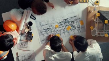 Becerikli mühendis ekibinin ev inşaatından bahsedişinin en alt görüntüsü. Mimar ya da tasarımcı grubunun planlar hakkında beyin fırtınası yapmak için tartışan ve yazan hava görüşü. Hizalama.