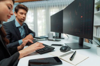 İki tüccar, dinamik borsada döviz oranı yatırım programı web sitesini iki bilgisayar ekranında analiz ediyor. Modern ofisteki gerçek zamanlı grafiği karşılaştırmak isteyen bir kadın. Varsayım.