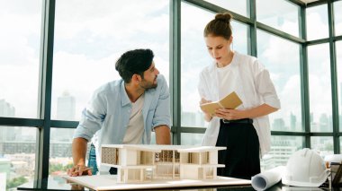 Yetenekli mimar mühendis takımı ev modeli inşaatı hakkında konuşuyor. Akıllı iç mimar paylaşımı, güzel bir iş arkadaşı not alırken bina tasarımından bahsetmek. Tasarım. İzleme