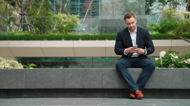 Kafkas işadamı, yatırımcılarla pazarlama stratejisi hakkında konuşurken parkta oturuyor. Mutlu akıllı yönetici, artan satışlar ya da Eko City 'de başarılı bir proje arıyor. Yaşam tarzı. Urbane