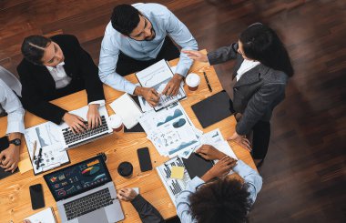 Modern toplantı odasındaki TV ekranında veri analizi paneliyle üst görünüm iş sunumu. İş adamlarının iş pazarlama stratejisini planlamak için beyin fırtınası yapması ya da birlikte çalışması. Uyum