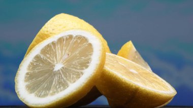 A slice of lemon, bright yellow and vibrantly citric, lies exposed. The yellow flesh, with refreshing juice, reveals its segmented interior. The essence of citrus vibrancy. Slow motion. Comestible. clipart