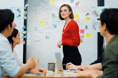 Profesyonel çekici kadın lider, modern iş toplantı odasında beyin fırtınası zihin haritalama istatistikleri ve renkli yapışkan notlar kullanarak yaratıcı pazarlama planını sunuyor. Tertemiz..