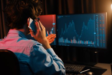 Genç yatırımcı borsacı brokerla birlikte arıyor. Yatırım değişimlerini gösteren bir monitörle güncel piyasa grafiğinde gerçek zamanlı olarak en yüksek karı elde etmek için. Toplayıcı.