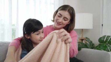 Kafkas anne örtüsü kızını battaniyeyle rahatlatırken kızın başını nazikçe ovuyordu. Akıllı anne yorulmuş okul kızını battaniyeye sararken samimi sevgi ve şefkat kavramlarıyla ilgilenir. Pedagoji.