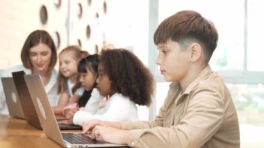 Çocuk BTMM Teknoloji sınıfında çok kültürlü bir arkadaşla bilgisayar oyunu oynuyor. Mühendislik kodları ve bulanık geçmişi olan programlama sistemi üzerine çok kültürlü bir öğrenci çalışması. Etkinlik.