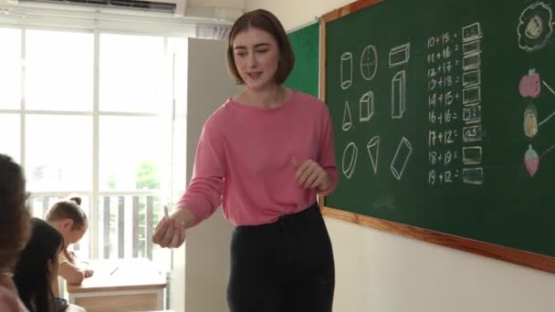 Кваліфікований Кавказький Вчитель Дивиться Африканську Дівчину Яка Пише Відповідь Дошку — стокове відео