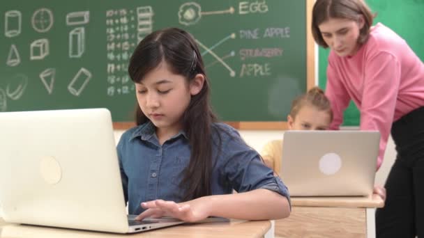 聪明的亚洲女孩一边看着相机一边编码工程技术提示 多元文化学生在科学 工程和数学课上教授系统或检查课堂教学时 学习产生人工智能的知识 教育学 — 图库视频影像