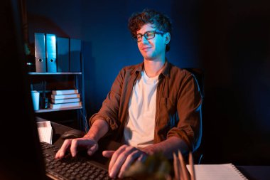 Yaratıcı bir başlangıç projesi için bilgisayara bağlanan genç iş adamı. Neon Light Modern Ofis 'in yeni planlayıcısı. Düşünüyorum da, pazarlama ağı yaratıcıdan pazar kanalı tasarım konseptine çevrimiçi planlama. Toplayıcı.