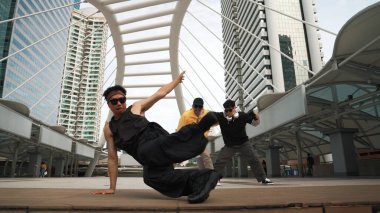 Bir grup profesyonel sokak dansçısı neşelen Asyalı hippi şehirde serbest dans ederken düşük açılı kamerayla çevrili insanlar tarafından. Break dans konsepti. Açık hava sporu 2024. Yumuşak bir şekilde..