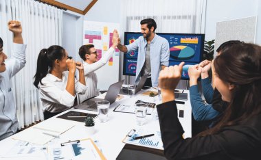 Analist ekip lideri, iş zekası veya BI gösterge paneli ile FIntech yazılım gücünü kullanarak yaptığı başarılı veri analizi toplantısından sonra iş arkadaşıyla birlikte kutluyor ve beşlik çakıyor. Tedbirli