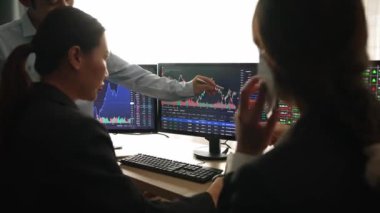 Hisse senedi borsası pazarlamasını analiz eden yavaş çekim şirketindeki yatırımcılar, kayıp için mum bar fiyatını analiz eden monitörlere bakıyor ve kazanç ve kâr elde ediyor. Filizlenen