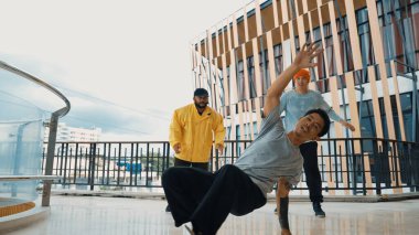 Hip hop takımı dans molası verirken, çok kültürlü bir arkadaş arkadaşını alkışlıyor ve alkışlıyor. Aktif ve enerjik sokak dansı. Açık hava sporu 2024. ÇalışmaComment.