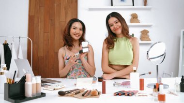 Etkilenen iki ortak canlı yayın yapan video görüntülerini sosyal medya ya da blog üzerinden gözden geçirir. Canlı kozmetik stüdyosu ışıklandırması olan mutlu genç bir kız pazarlama için internet üzerinden yayın yapıyor..