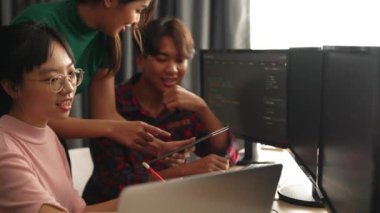 Yavaş çekim arkası yazılım geliştirici mühendisi bilgisayar programlama için birlikte çalışarak hata ayıklama kodunu çözüyor, ofiste monitörde karmaşık algoritmaları çözüyor. Filizlenen