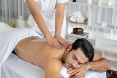 Kafkas erkek müşteri stres önleyici spa masajının keyfini çıkarıyor ve lüks otel veya oteldeki gündüz açık hava ortamında güzellik derisi eğlencesi ile şımartıyor. Sessiz.